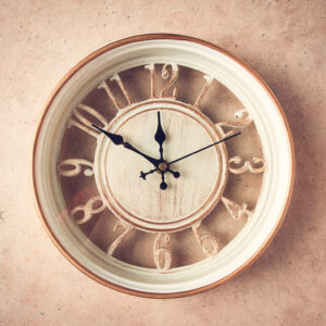 mechanical wall clock, transparent , beige color , on a light pa