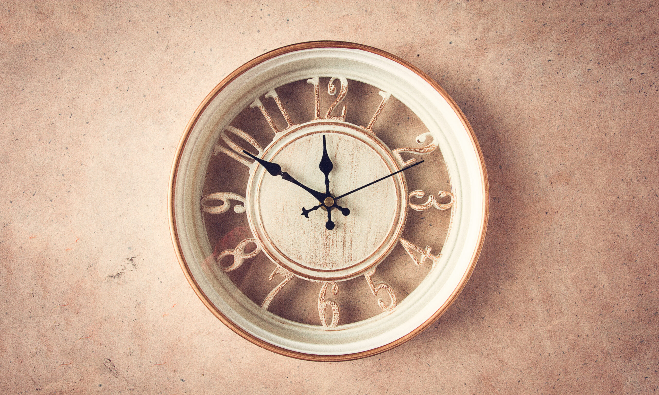 mechanical wall clock, transparent , beige color , on a light pa